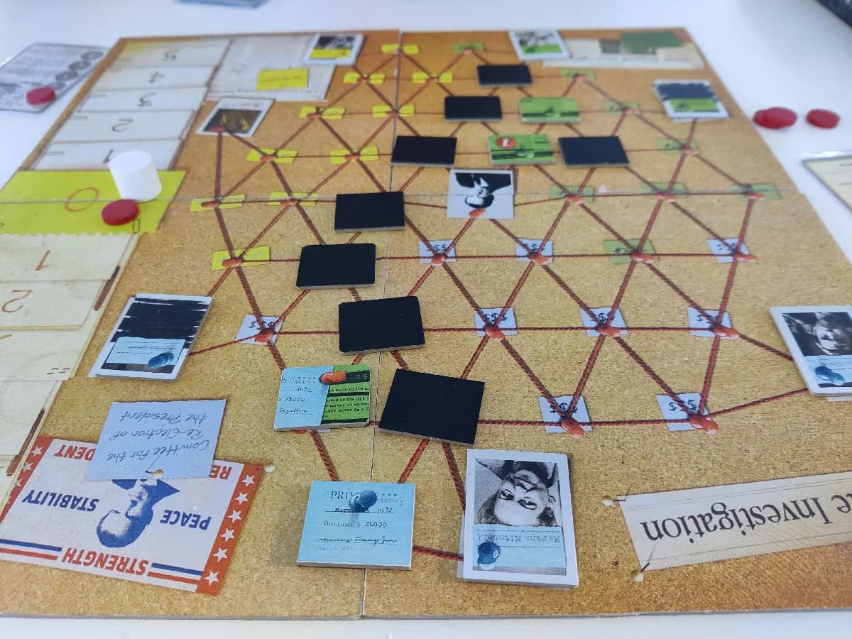 Watergate board game mid-play: evidence network board with black informant tiles, photo cards and red tokens